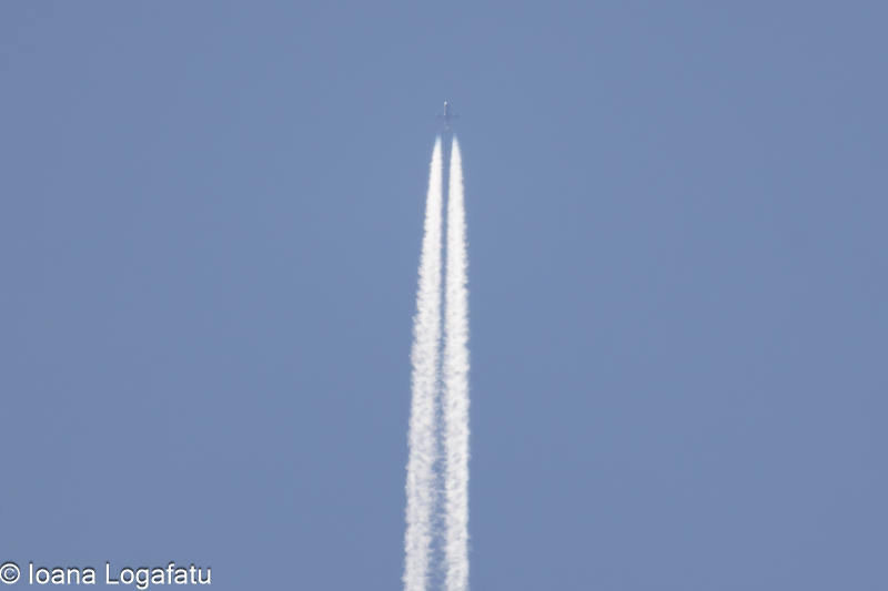 Contrails stretch across the clear blue sky